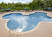 Thumbnail 15 of 31 - a swimming pool with chairs and umbrellas at a resort at Carrington Place at Wildewood, Columbia, 29223  
