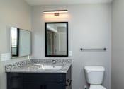 Thumbnail 11 of 23 - A bathroom with a sink, mirror, and toilet at Dunean Creek Apartments, South Carolina, 29611