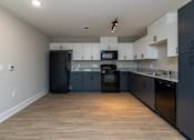 Thumbnail 3 of 23 - A kitchen with black appliances and wooden floors at Dunean Creek Apartments, South Carolina, 29611