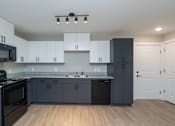 Thumbnail 4 of 23 - A kitchen with black and white cabinets and a black dishwasher at Dunean Creek Apartments, Greenville, SC