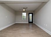 Thumbnail 5 of 23 - A room with a ceiling fan and a door leading to a balcony at Dunean Creek Apartments, Greenville, SC, 29611
