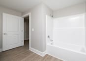 Thumbnail 14 of 23 - A white bathroom with a tub and a door at Dunean Creek Apartments, South Carolina, 29611