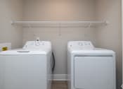 Thumbnail 19 of 23 - Two white front loading washing machines in a laundry room at Dunean Creek Apartments, Greenville, 29611