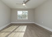 Thumbnail 16 of 23 - A room with a ceiling fan and a window with blinds at Dunean Creek Apartments, Greenville, SC, 29611