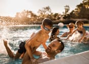 Thumbnail 5 of 16 - a family swimming in a pool with a child