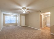 Thumbnail 1 of 11 - A room with a ceiling fan and carpeted floor at Lakeside Gardens Apartments, Durham, NC