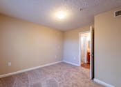 Thumbnail 4 of 11 - A room with a carpeted floor and a doorway leading to another room at Lakeside Gardens Apartments, Durham, NC