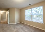 Thumbnail 8 of 11 - A room with a carpeted floor and a window with blinds at Lakeside Gardens Apartments, Durham, North Carolina