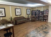 Thumbnail 5 of 6 - a waiting room of a library with wicker chairs and shelves of books
