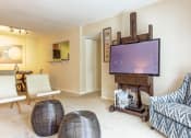 Thumbnail 10 of 17 - a living room with a television and a dining room in the background at The Bristol Apartments, South Carolina