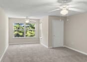 Thumbnail 1 of 6 - an empty living room with a ceiling fan and a window