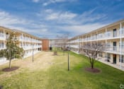 Thumbnail 22 of 28 - an open courtyard in an apartment building with grass and trees