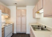 Thumbnail 8 of 28 - an empty kitchen with white appliances and wooden cabinets