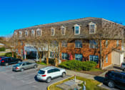 Thumbnail 25 of 28 - a large brick building with cars parked in front of it