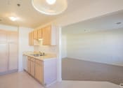 Thumbnail 14 of 28 - an empty kitchen and living room with a sink and cabinets
