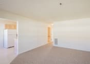 Thumbnail 2 of 28 - an empty living room and kitchen with a refrigerator and