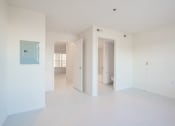 Thumbnail 10 of 28 - an empty living room with white walls and a blue door