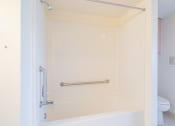 Thumbnail 12 of 28 - a bathroom with a shower and a toilet in it