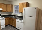 Thumbnail 13 of 21 - a kitchen with white appliances and wooden cabinets at Pendleton Townhomes Apartments, Durham, NC