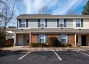 Thumbnail 6 of 21 - the front of an apartment building with a parking lot at Pendleton Townhomes Apartments, North Carolina