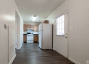 Thumbnail 12 of 21 - an empty kitchen with white appliances and wood floors at Pendleton Townhomes Apartments, Durham