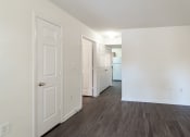 Thumbnail 11 of 21 - the living room of an apartment with white walls and wood flooring at Pendleton Townhomes Apartments, Durham, North Carolina