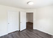 Thumbnail 16 of 21 - an empty bedroom with white walls and wood flooring at Pendleton Townhomes Apartments, North Carolina