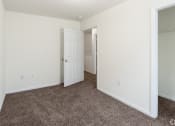 Thumbnail 17 of 21 - an empty bedroom with carpet and a door to a closet at Pendleton Townhomes Apartments, North Carolina 27703