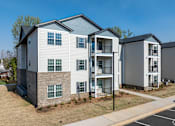 Thumbnail 22 of 23 - A row of modern townhouses with balconies and garages at Dunean Creek Apartments, Greenville, 29611