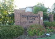 Thumbnail 1 of 19 - a brick sign in front of a building with a gate