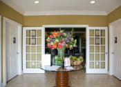 Thumbnail 8 of 19 - a vase of flowers on a table in a room with doors