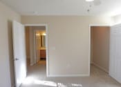Thumbnail 18 of 19 - a bedroom with two closets and a hallway leading to a bathroom and a door