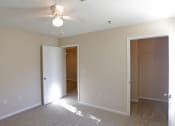 Thumbnail 13 of 19 - an empty living room with a ceiling fan and a closet