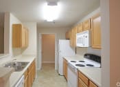 Thumbnail 15 of 19 - a kitchen with white appliances and wooden cabinets