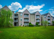 Thumbnail 1 of 15 - an apartment building with a green lawn