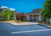 Thumbnail 2 of 15 - a driveway in front of a house with a parking lot