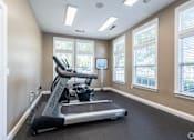 Thumbnail 15 of 26 - A treadmill in a room with a TV and windows.