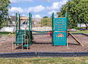 Thumbnail 20 of 26 - A playground with a green slide and a red and green play structure.