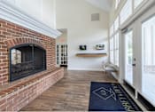 Thumbnail 3 of 26 - A brick fireplace is in a room with a blue rug on the floor.