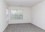 Thumbnail 11 of 26 - A room with a window and a carpeted floor.