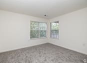 Thumbnail 10 of 26 - A room with a carpeted floor and two windows.