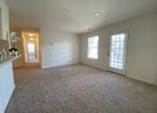 Thumbnail 7 of 26 - A large, empty room with carpeted flooring and two windows.