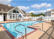 Thumbnail 16 of 26 - A swimming pool in a residential area with a house in the background.