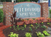 Thumbnail 5 of 13 - a sign for wildwood springs in front of a brick garden