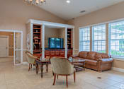 Thumbnail 12 of 17 - A living room with a brown leather couch and a wooden coffee table.