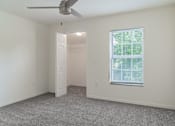 Thumbnail 4 of 17 - A room with a ceiling fan and a window with blinds.