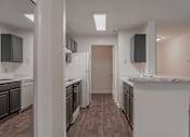 Thumbnail 6 of 17 - A kitchen with white appliances and dark wood floors.
