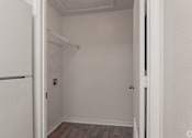 Thumbnail 5 of 17 - A white closet with a white door and a white wall.