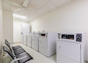 Thumbnail 6 of 13 - A row of washing machines in a laundromat.