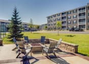Thumbnail 4 of 32 - a patio with chairs and a fire pit in front of an apartment building  at Boulder Ridge, Duluth, MN 55811